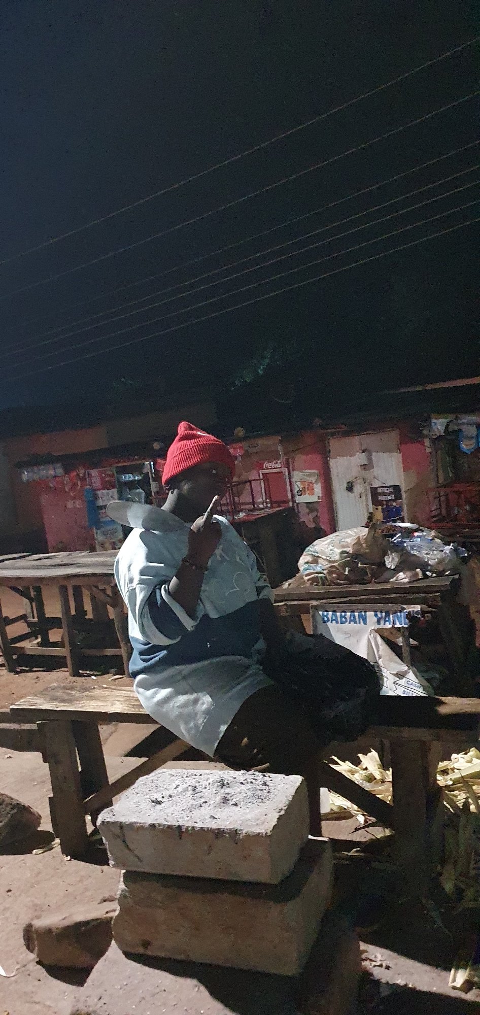 Busy nighttime street market with overloaded vehicles and foot traffic