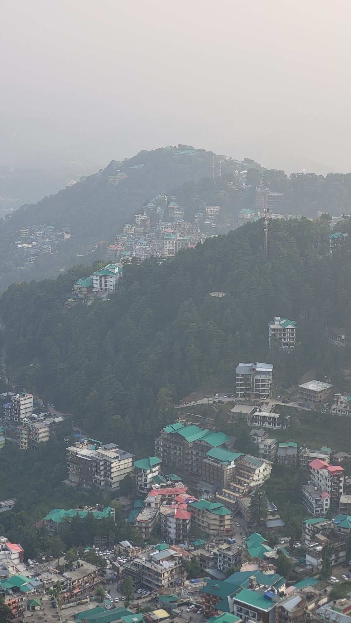 Misty aerial view captured over hillside village of Dharamkot