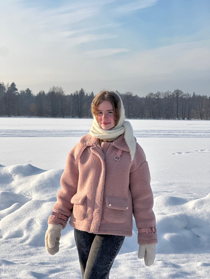 Woman explores snowy Russian monastery grounds with ice sculptures