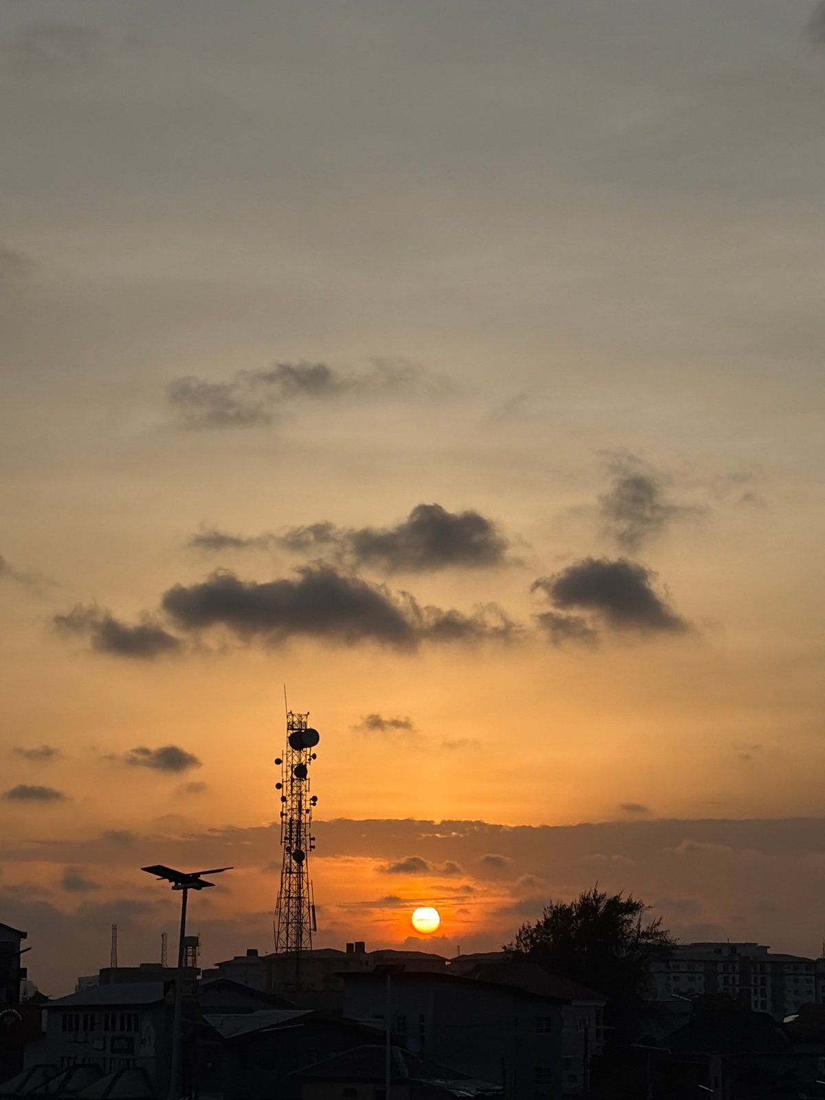 Sunset observed behind buildings and tower in Igboefon, Nigeria