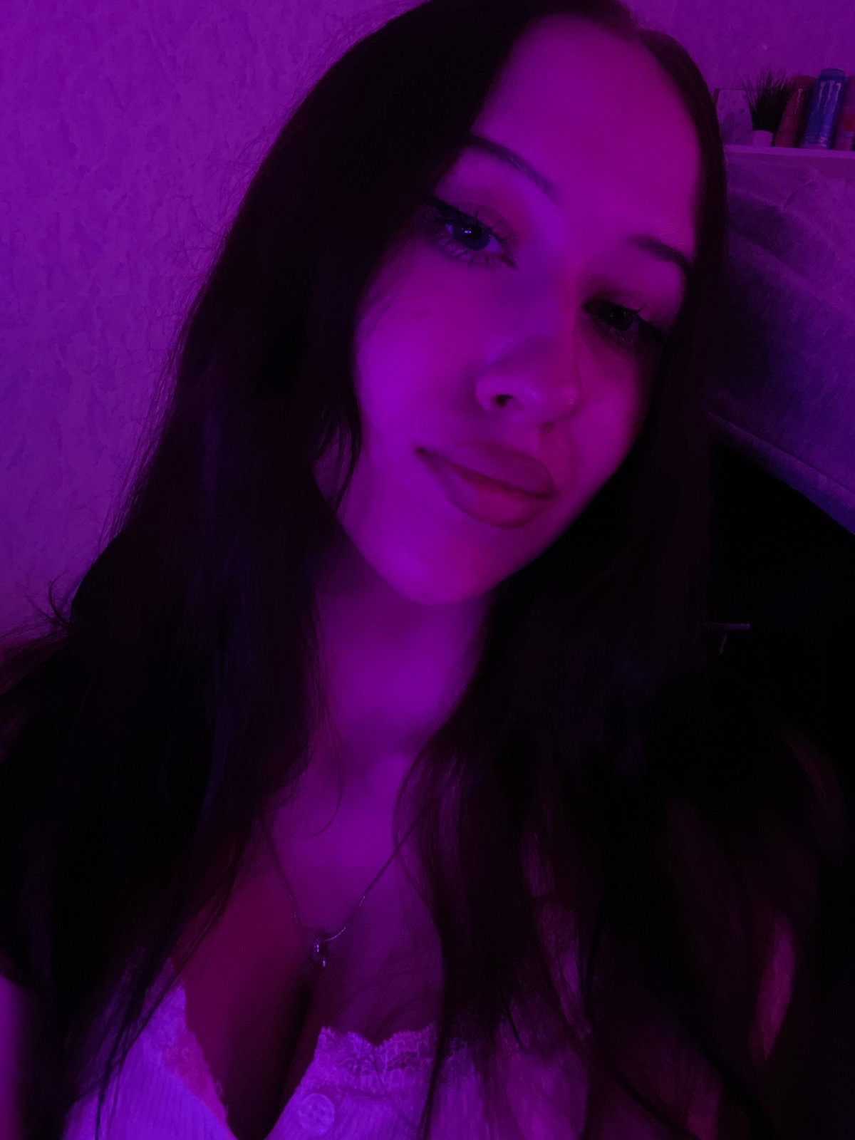 Woman documents evening with selfies in pink-lit Votkinsk bedroom