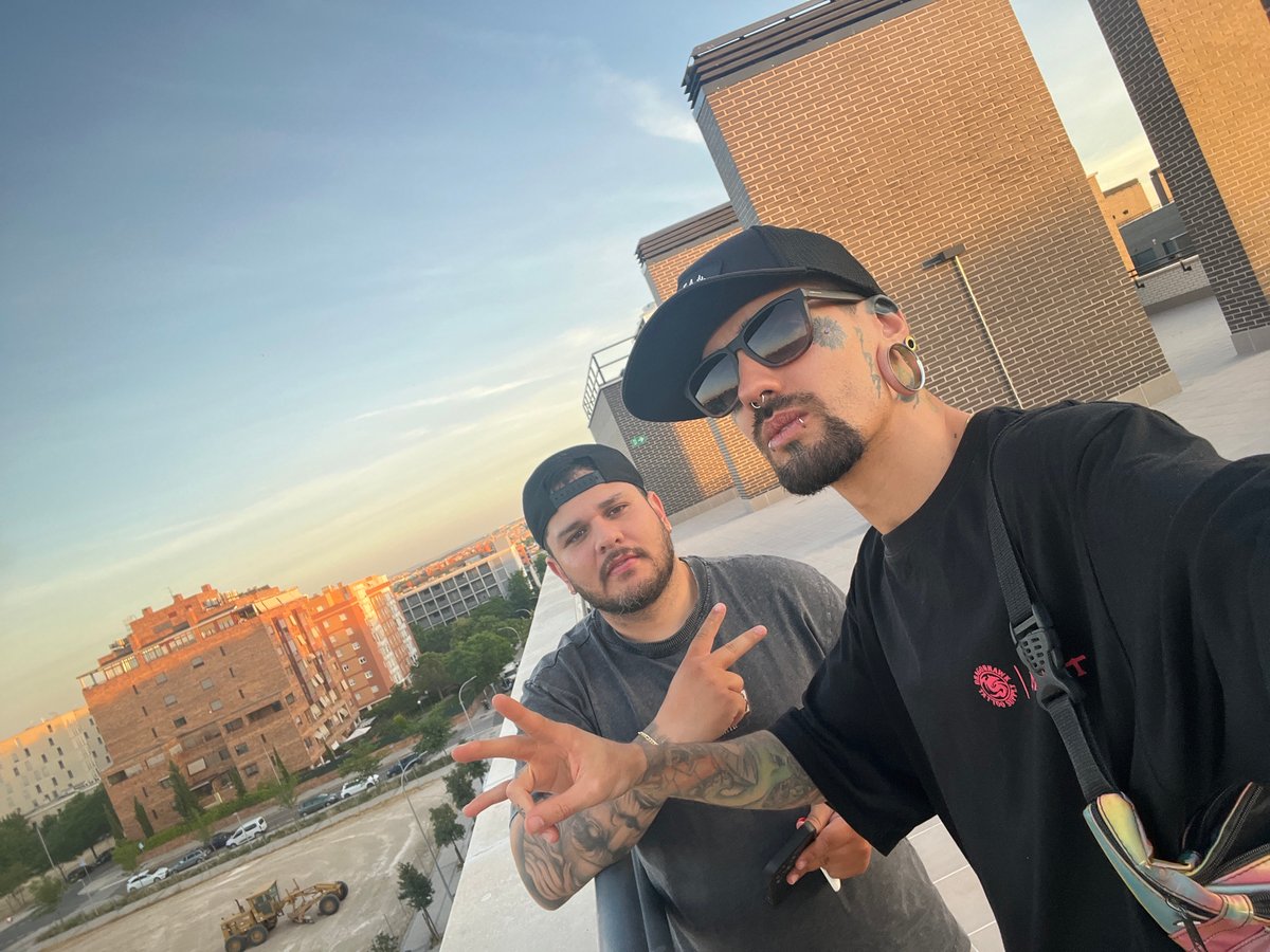 Tattooed individual photographs Madrid sunset from rooftop balcony