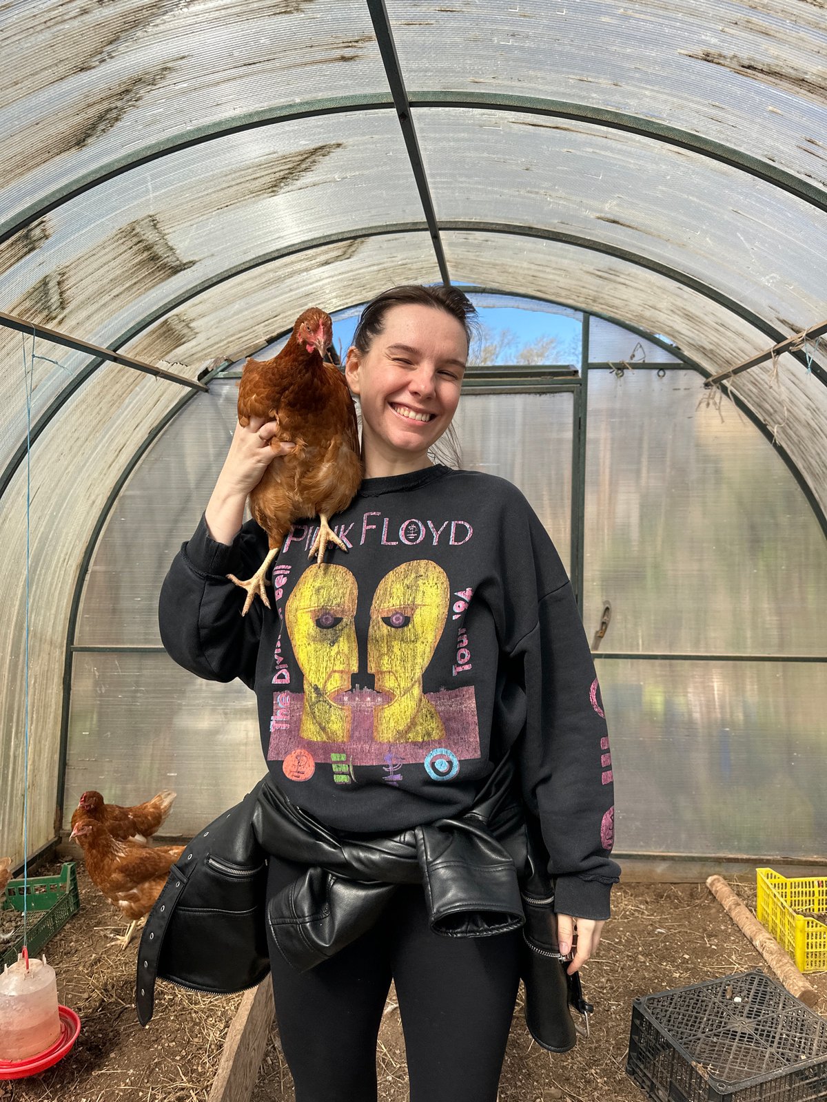 Woman poses with chicken in greenhouse structure in Альняш