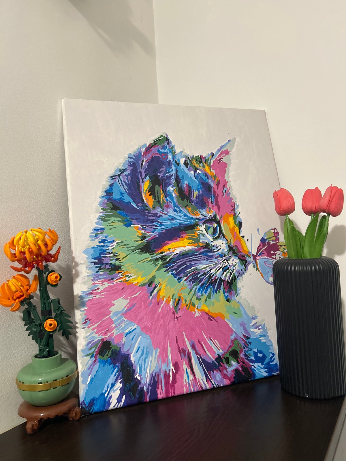 Abstract Animal Painting Displayed with Floral Decorations Against Wall