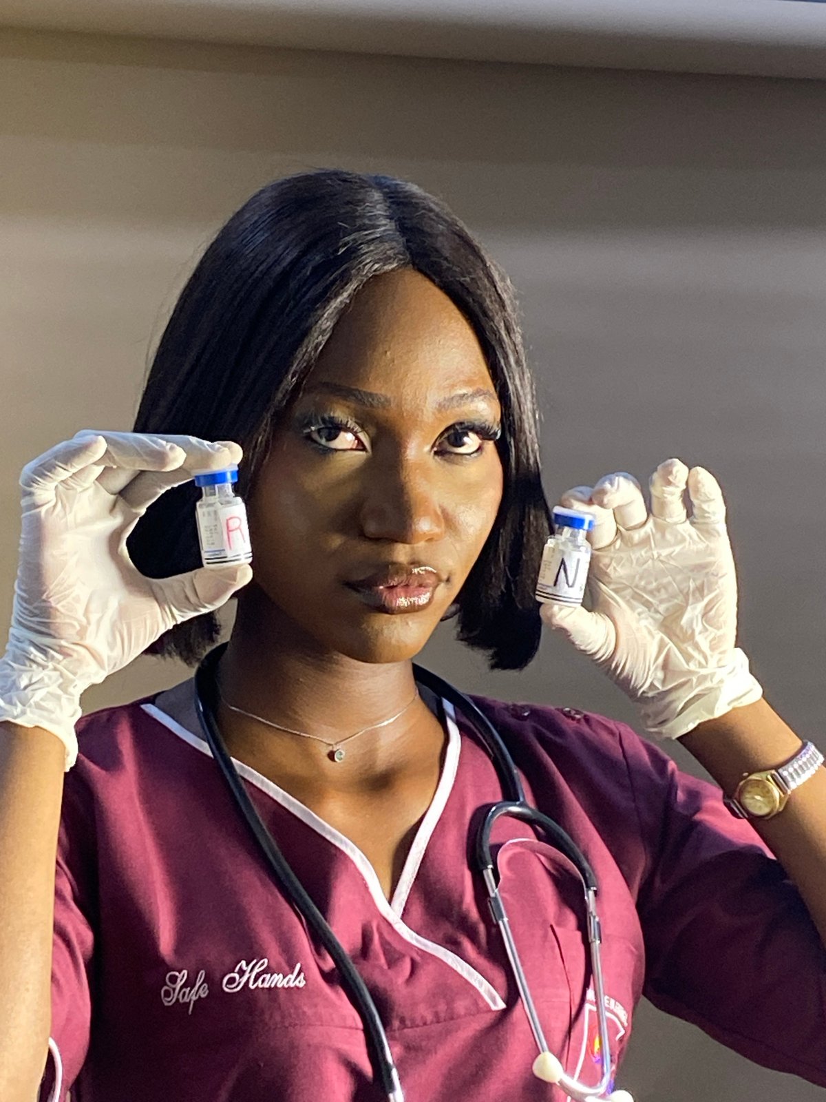 Healthcare worker poses with medication vials in Nigeria studio session