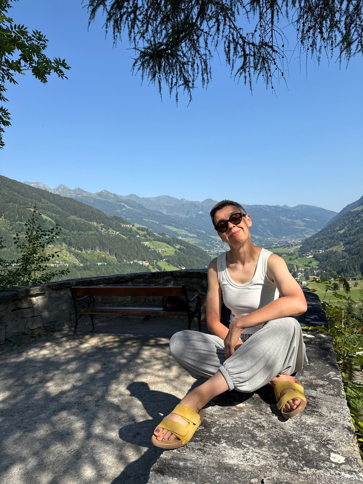 Relaxing on a stone ledge with Austrian mountain valley views