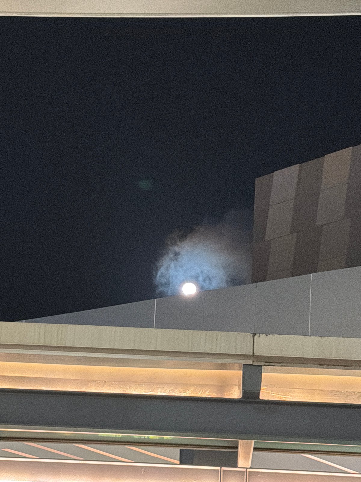 Moon framed by modern architecture in nighttime Cancún