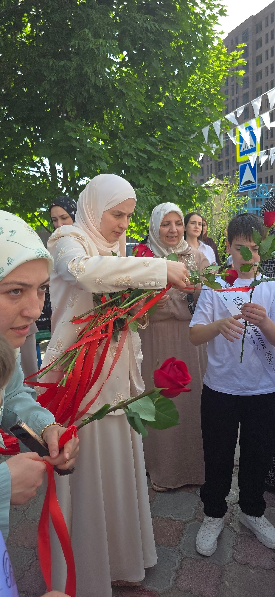 Memorial gathering with roses, balloons observed at educational facility