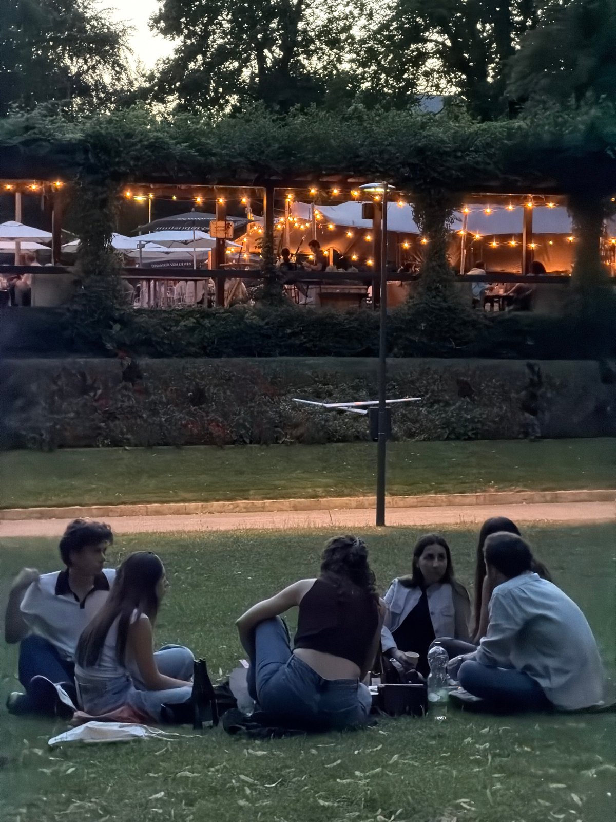 Evening gathering near an illuminated sculpture in Luxembourg City