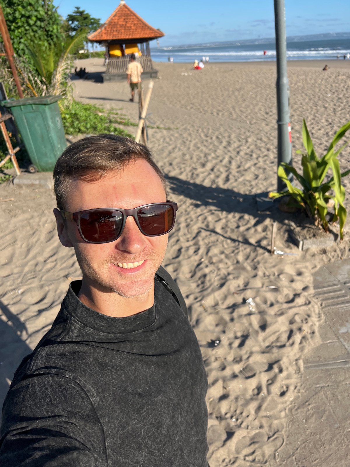 Morning beach scene in North Kuta, Bali — people, dogs, and shoreline life
