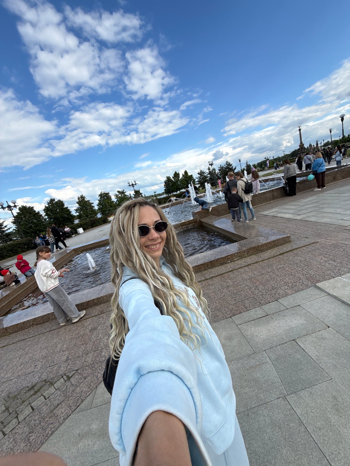Woman photographs herself at fountain in Rusanovo, Russia