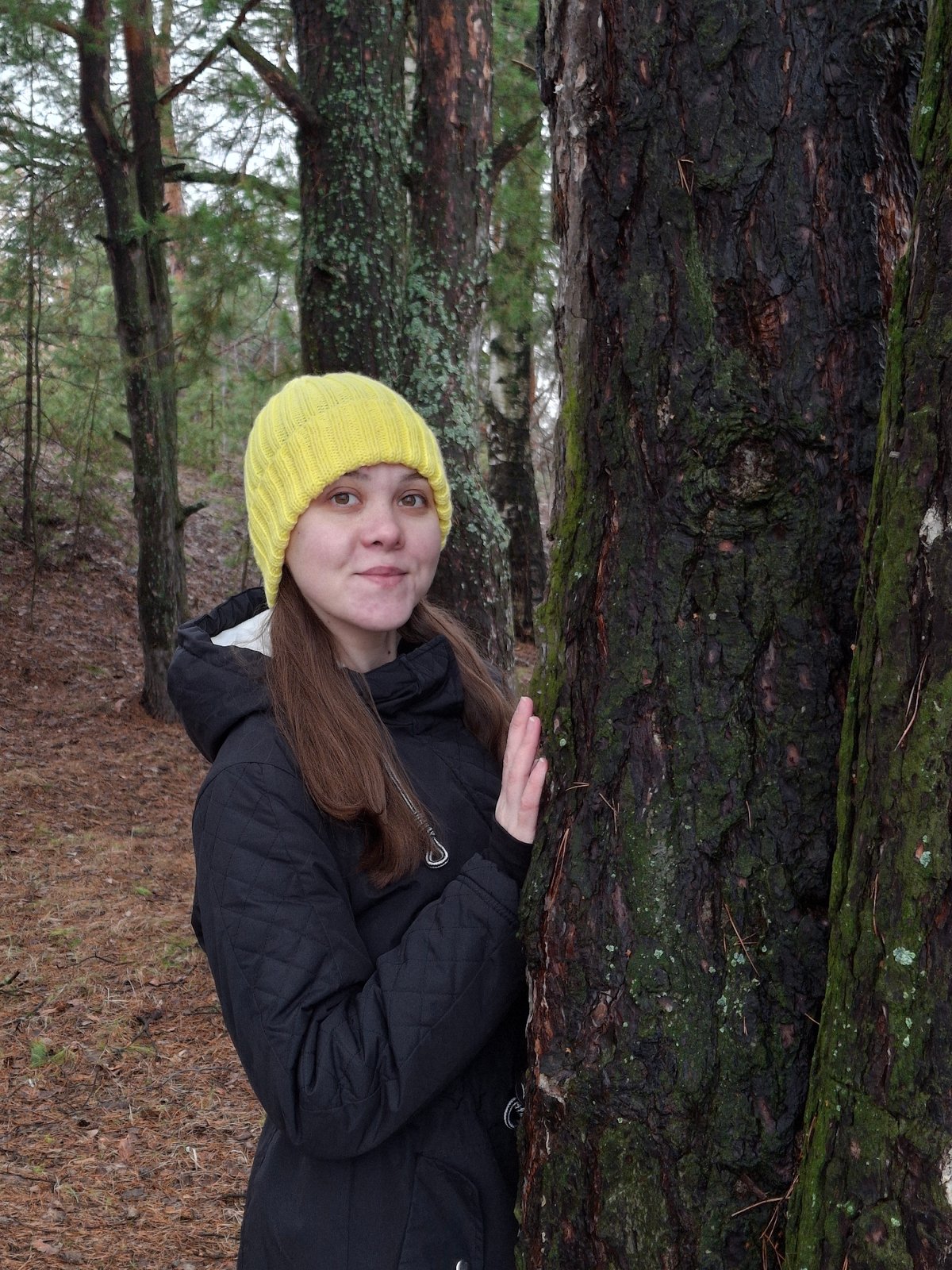 Person in yellow beanie explores winter forest in Chaikovsky