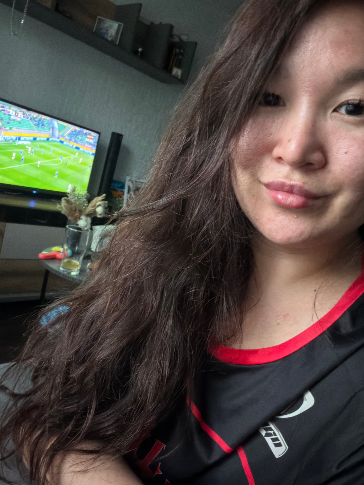 Person takes selfie while watching soccer match on television