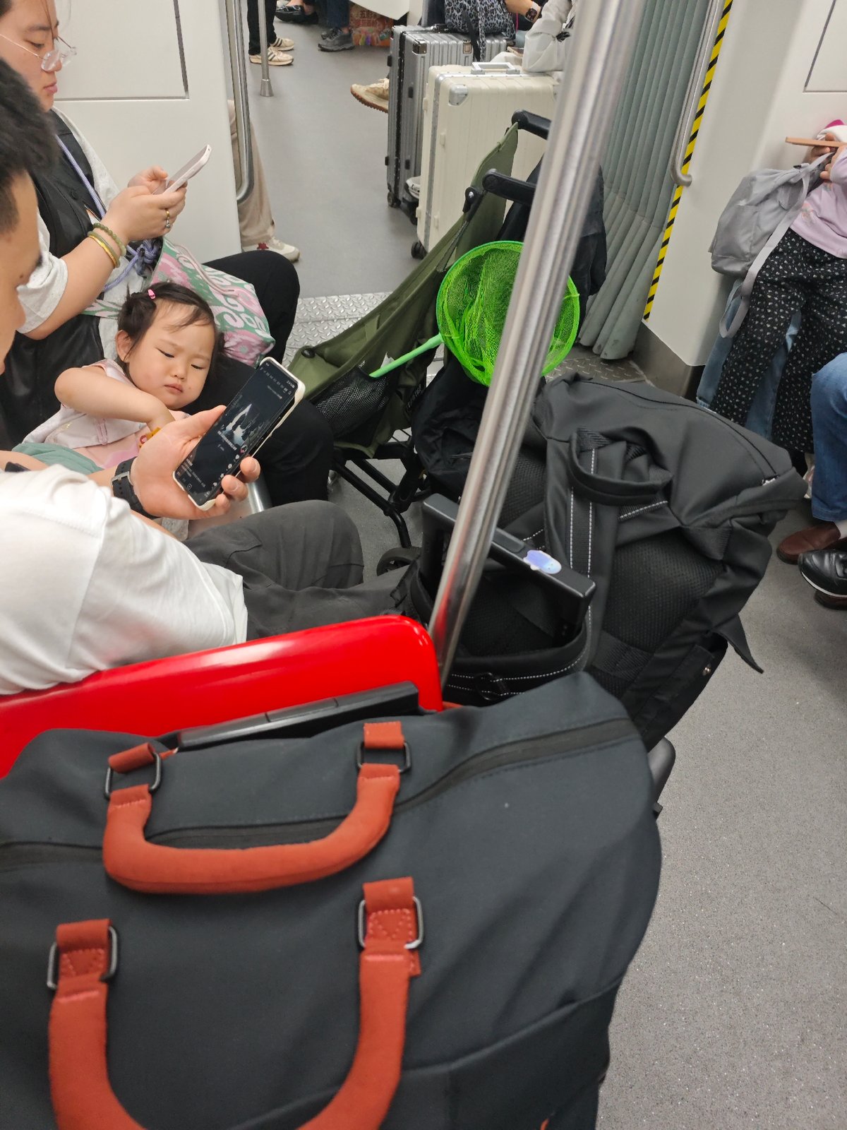 Child shares smartphone with adult during public transit journey