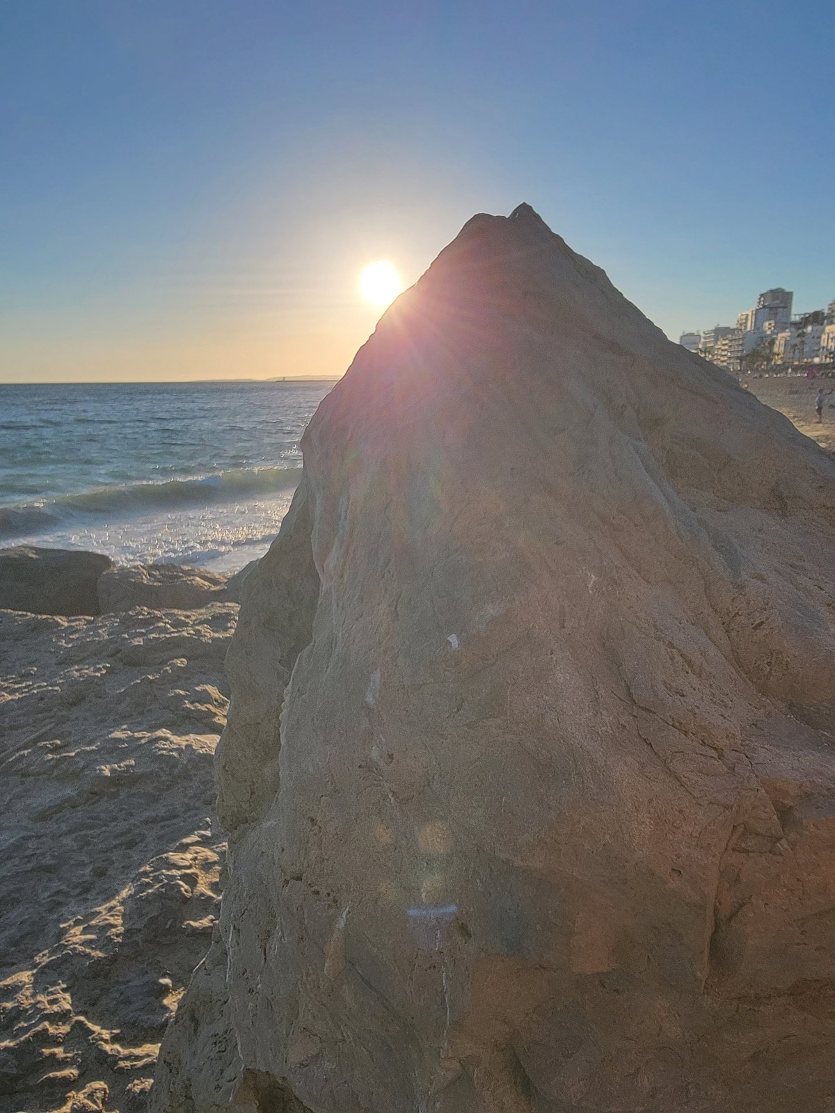 Quarteira beach at golden hour, rocks to promenade