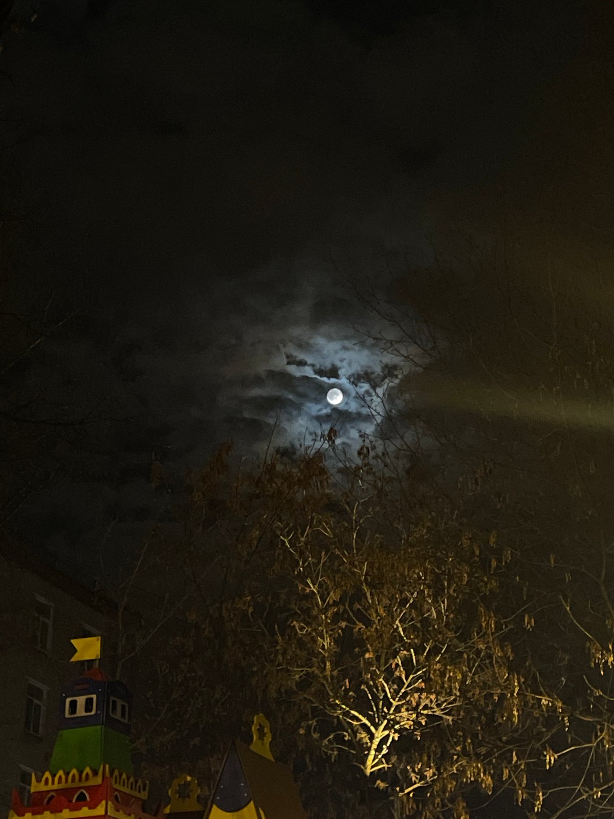 Full moon visible through clouds in Moscow nighttime scene