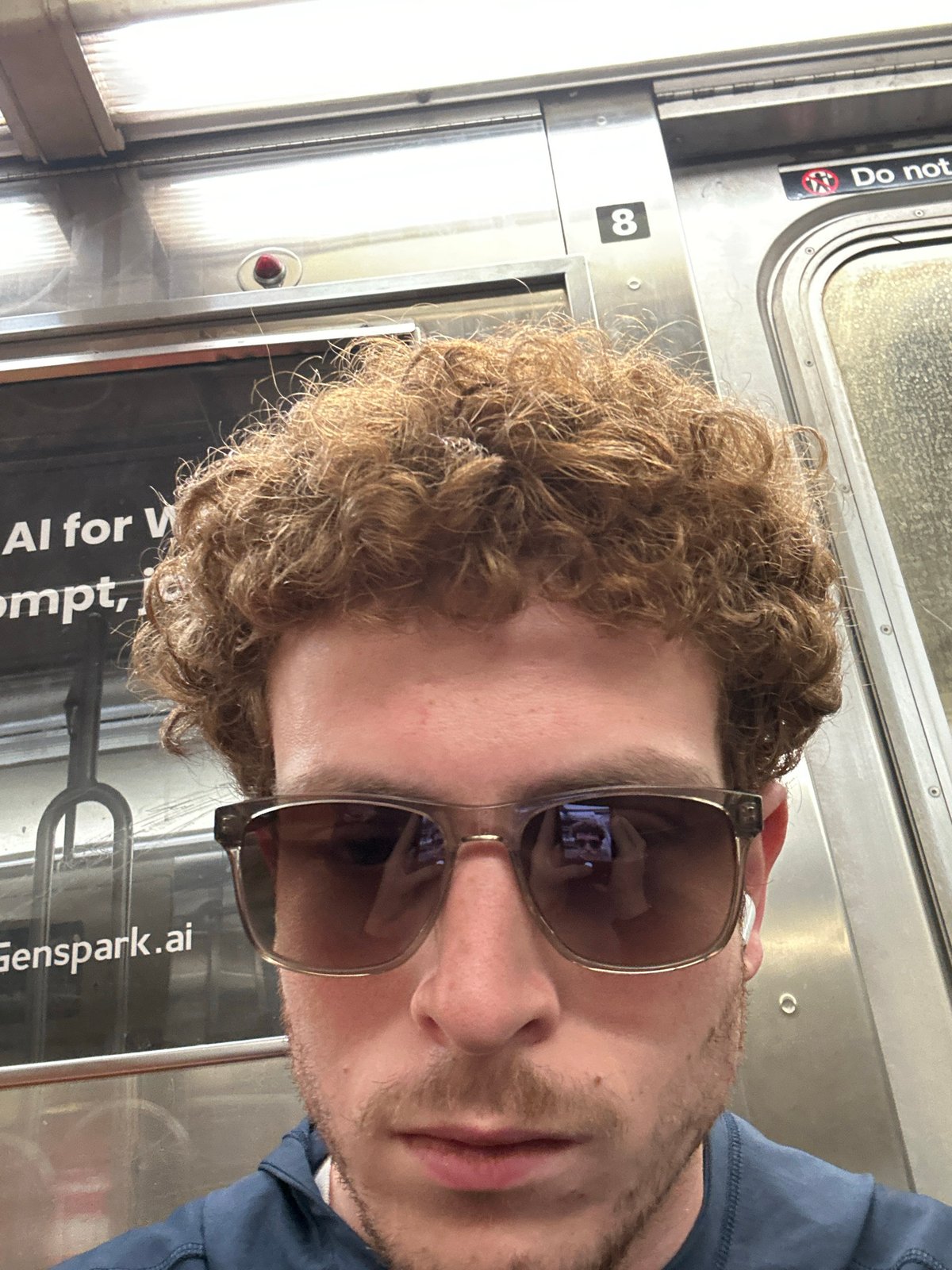 Portrait photo captures person in sunglasses, blue shirt in NYC