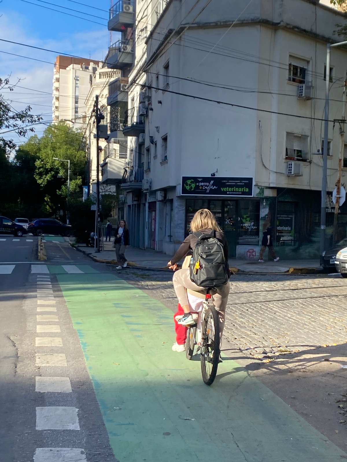 Woman cycles through Buenos Aires bike lane near veterinary clinic