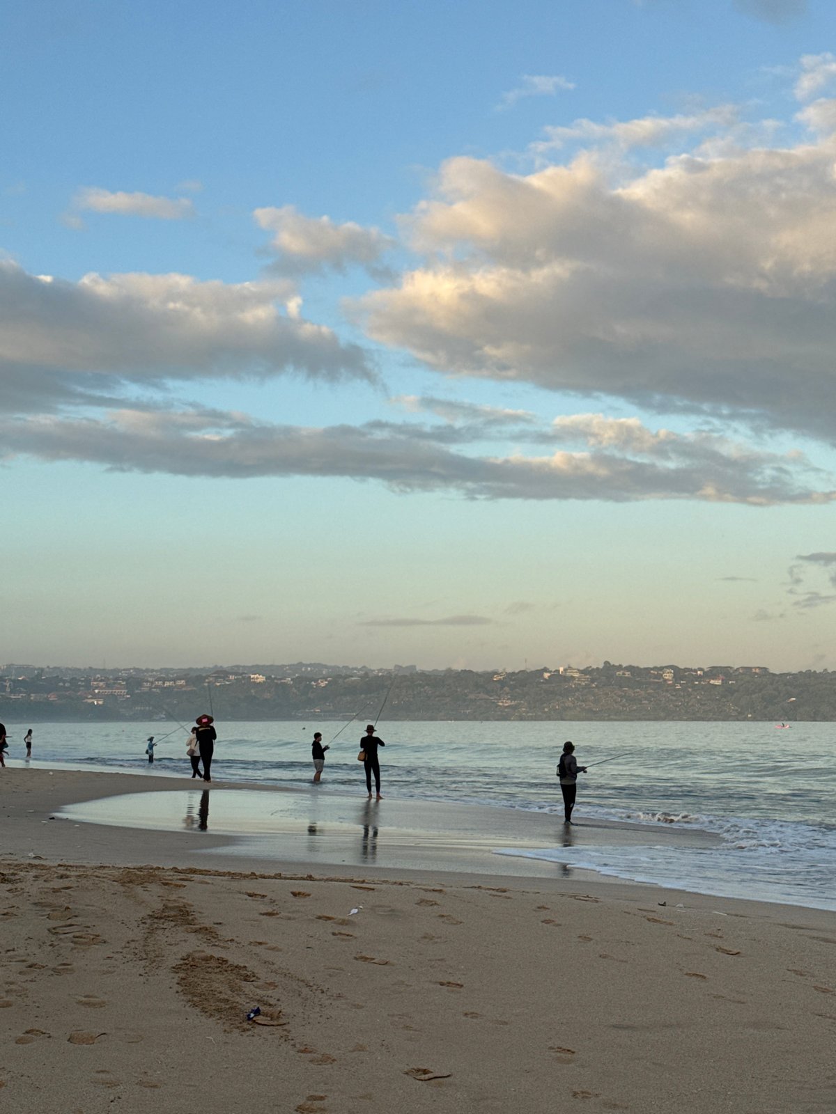 Evening fishing and beach activity observed in Kuta