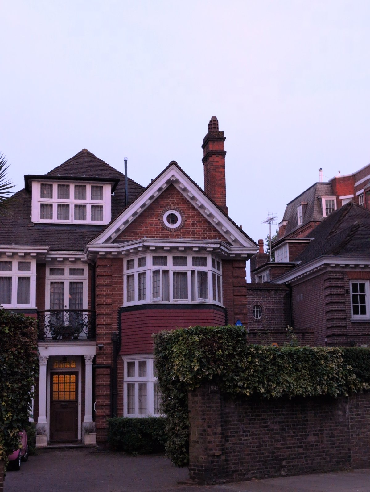 Suburban London street at dusk, brick houses and tree-lined road