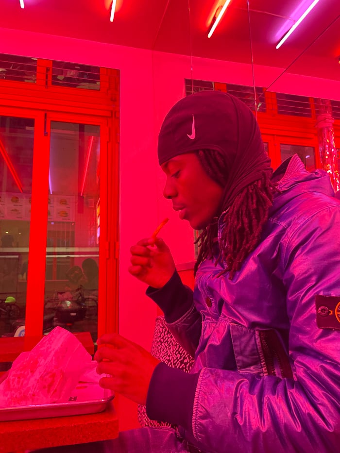 Solo diner enjoys burger meal at neon-lit Paris restaurant