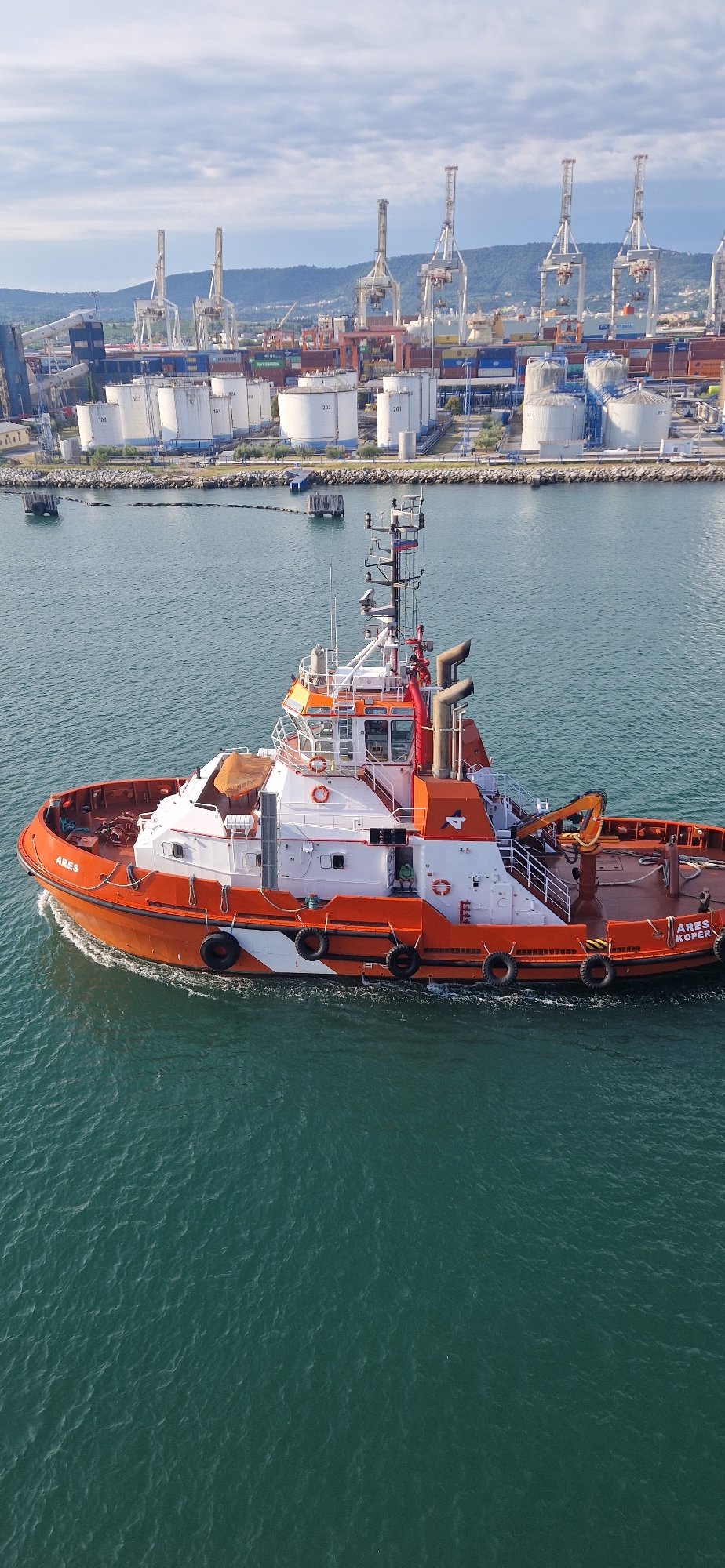 Tugboat ARES KOPER navigating Ankaran port on a clear morning