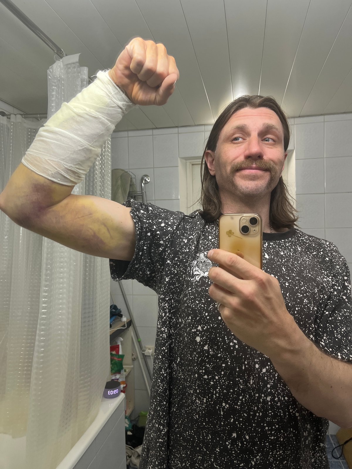 Man Takes Mirror Selfie in Bathroom Wearing Patterned Shirt