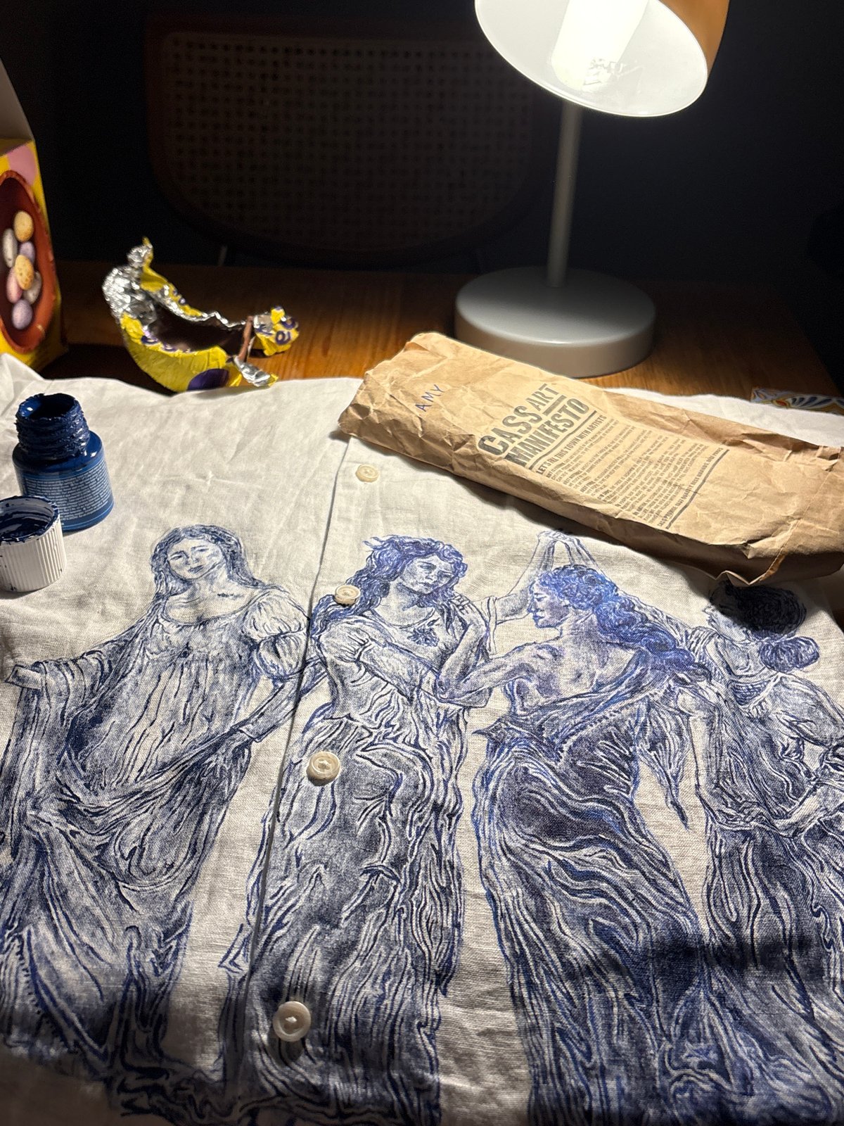 Desktop scene with lamp, chocolate wrapper captured in Manchester