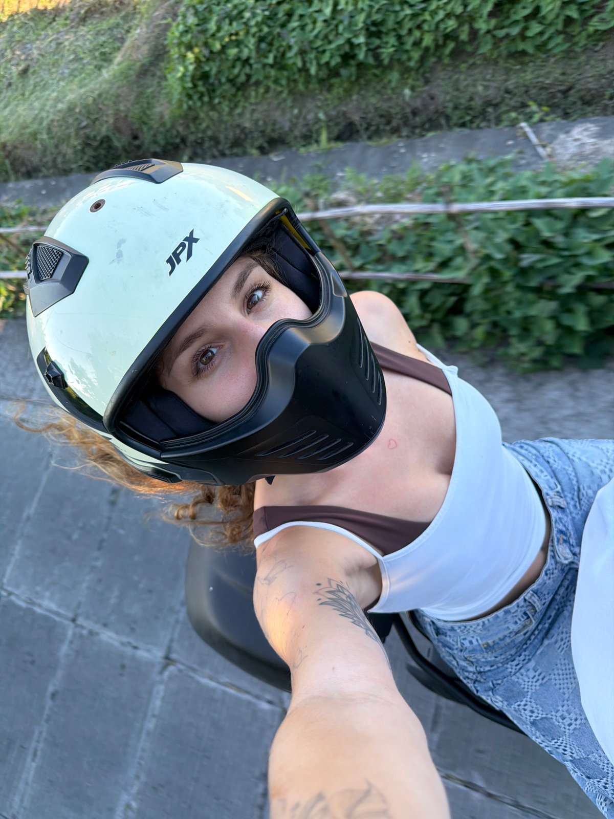 Woman in JPX helmet takes selfies near motorcycle in North Kuta