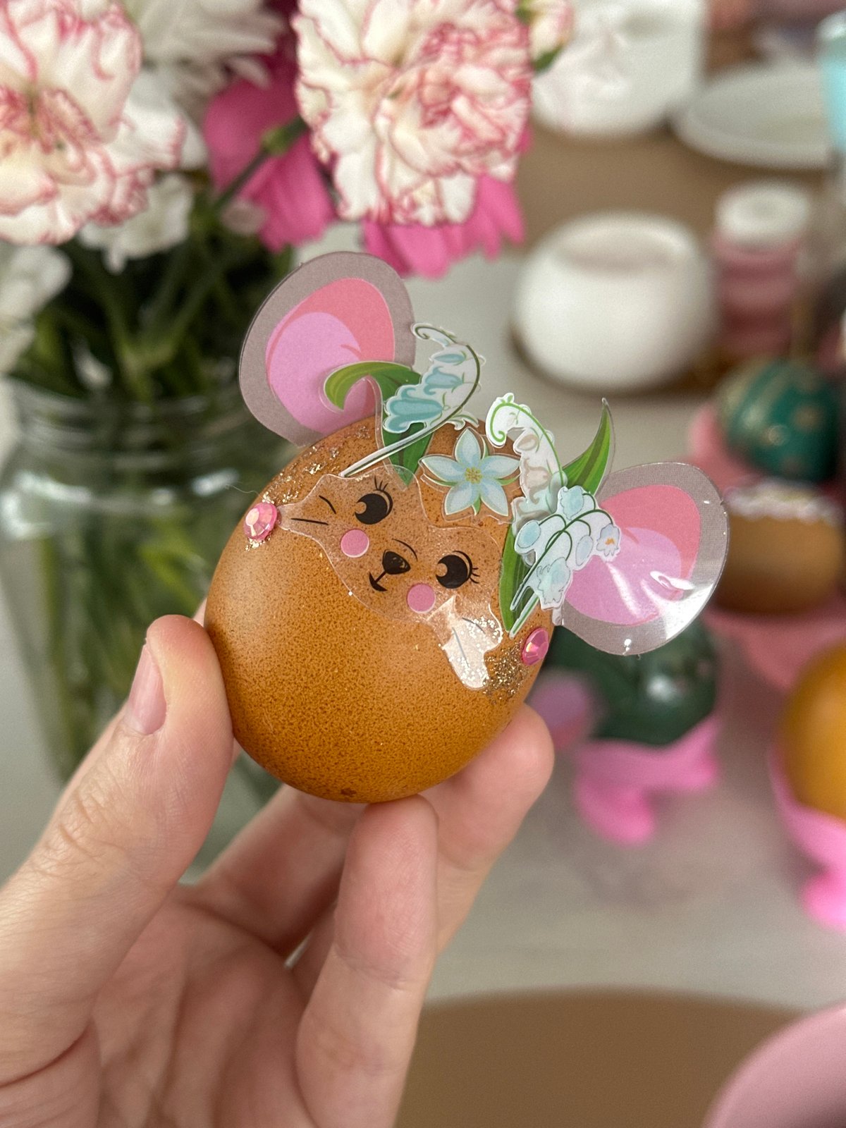 Person displays mouse-decorated Easter egg in Kharnavy, Russia
