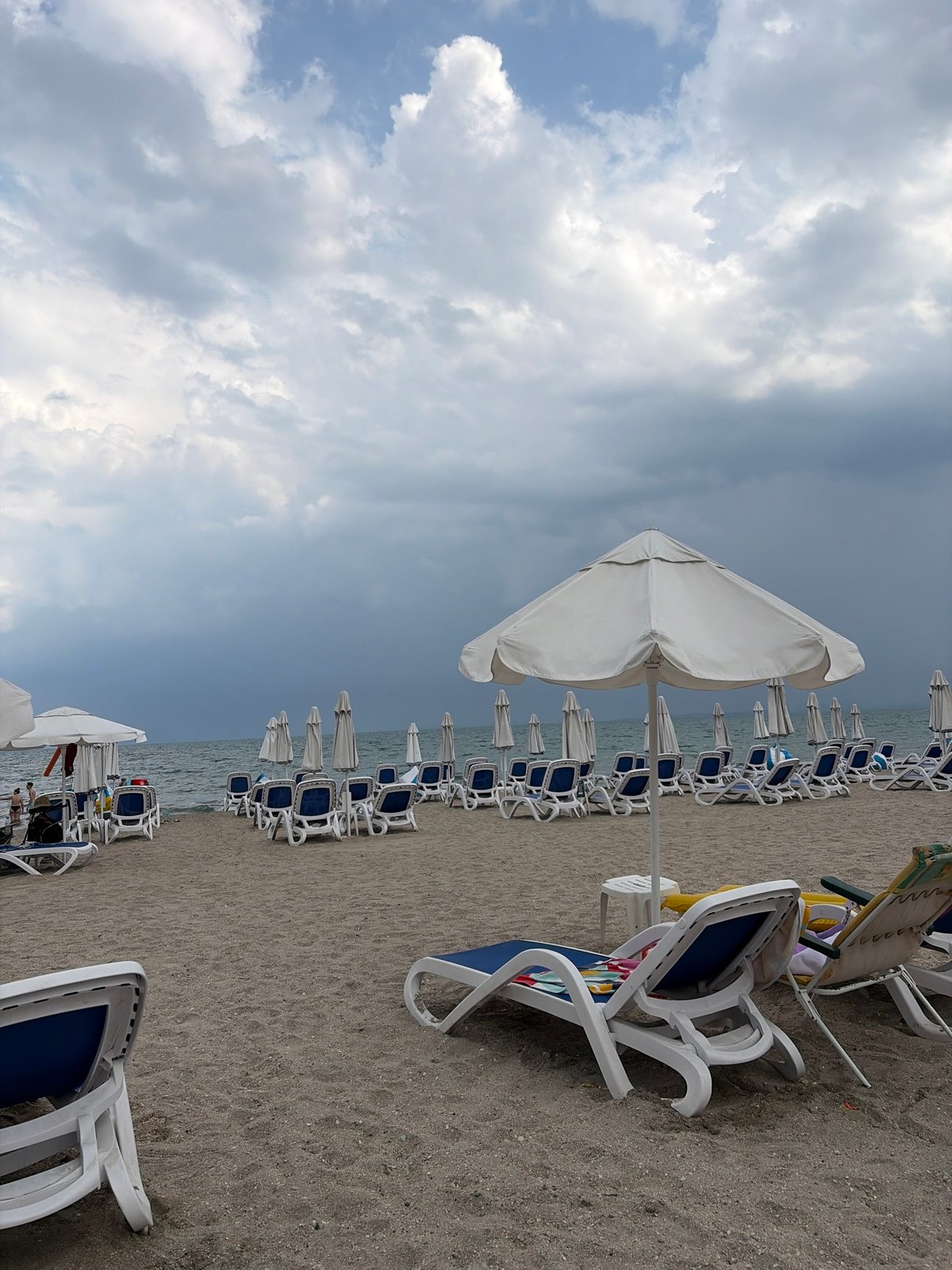Empty lounge chairs on a cloudy Pomorie beach