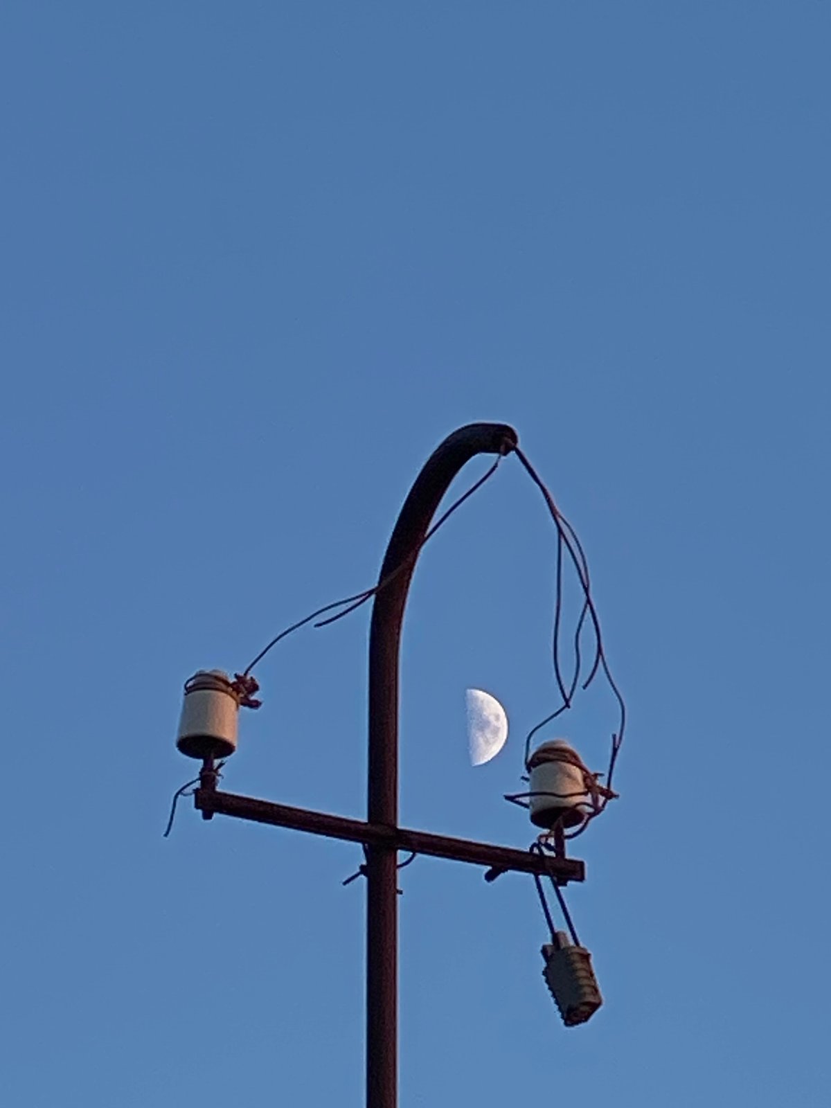 Sunset, moon, and utility poles fill the Cairaclia sky