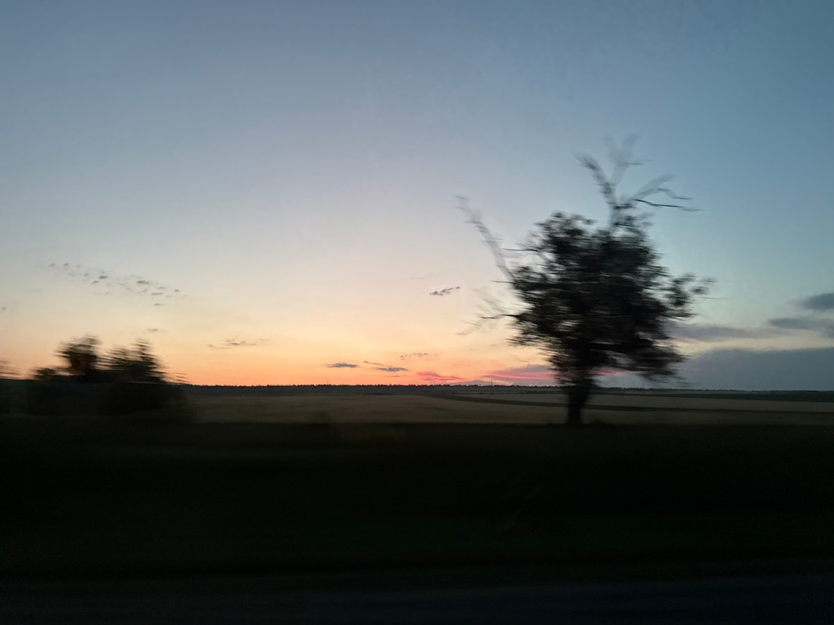 Evening road trip through open countryside at sunset