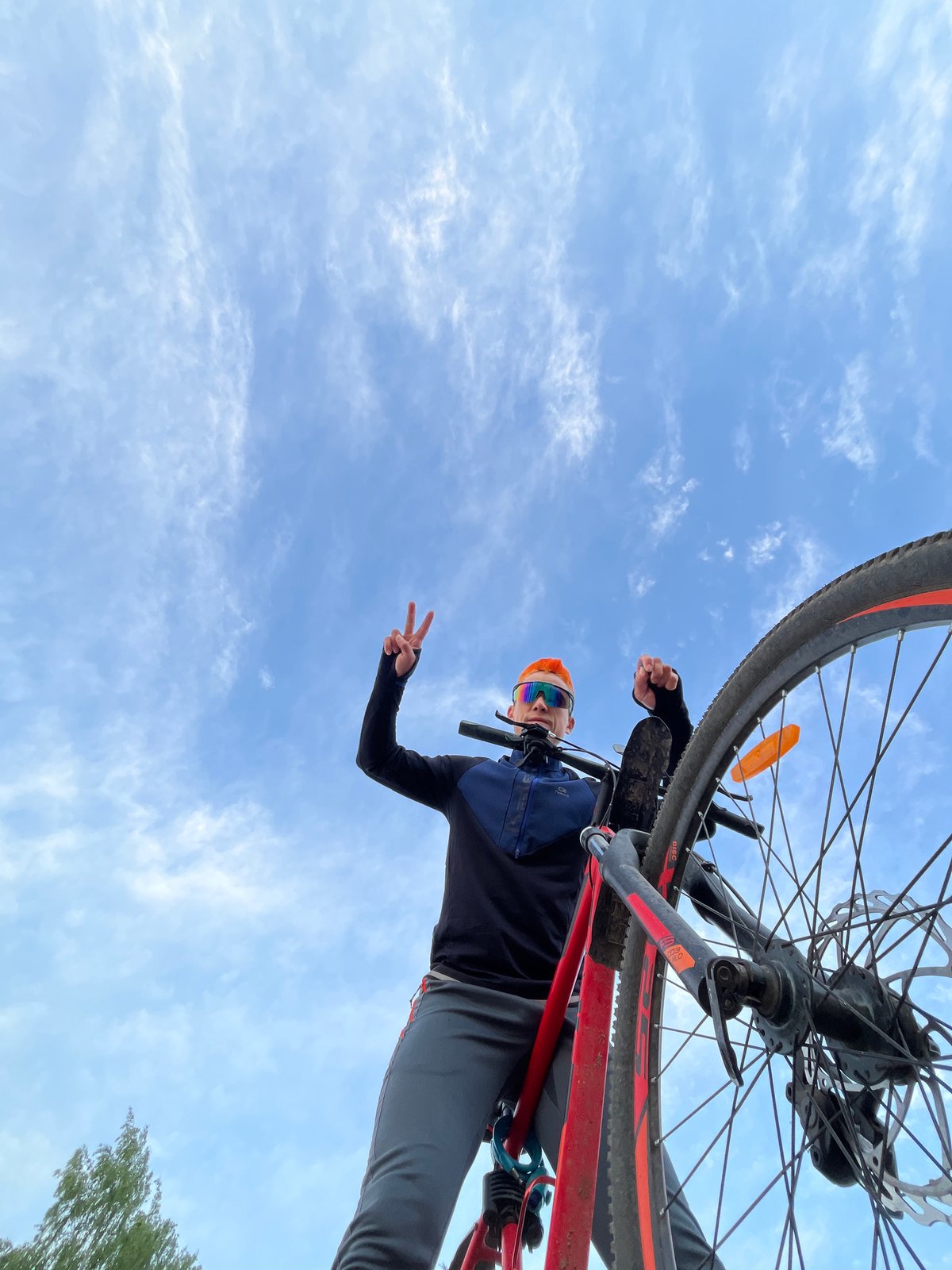 Cyclist holds bicycle overhead in Chaikovsky, Russia