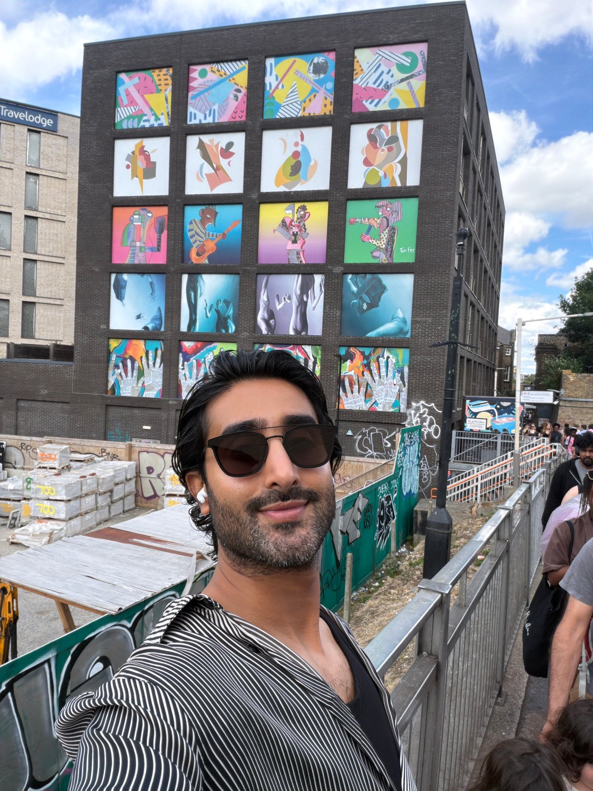 Street activity around a colorful mural building in London