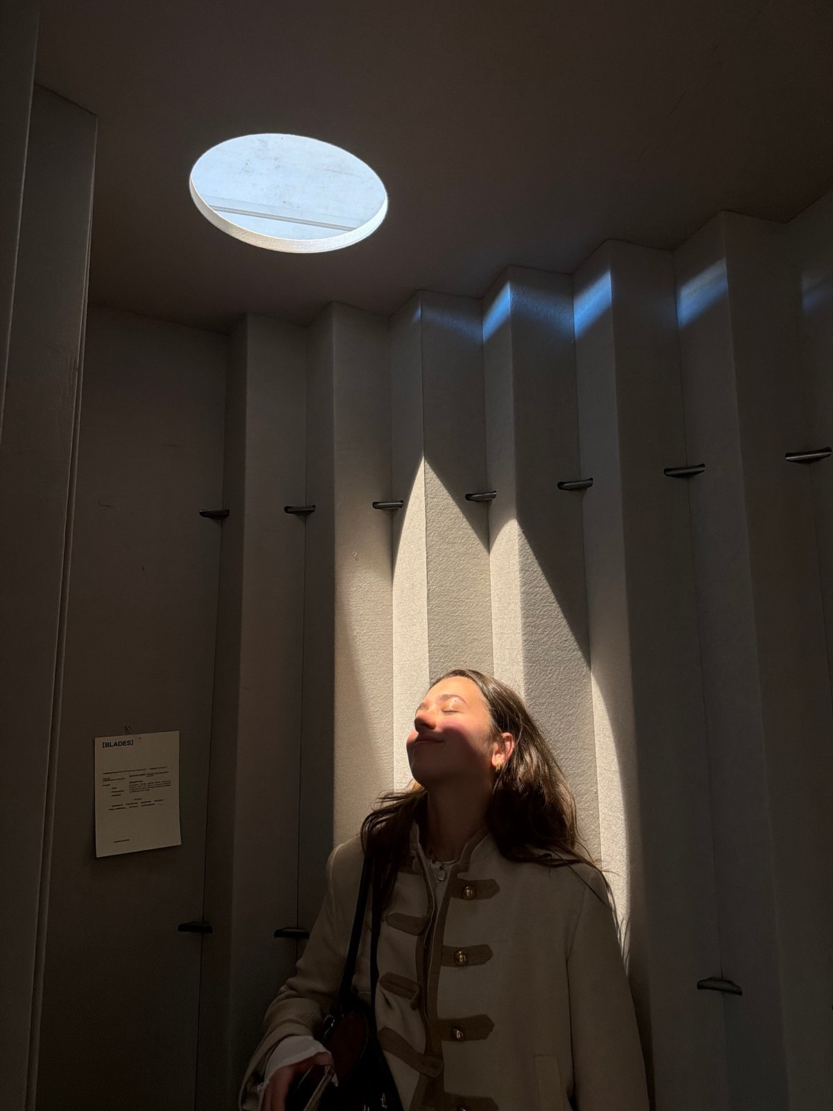 Woman photographed on sunlit staircase in minimalist setting