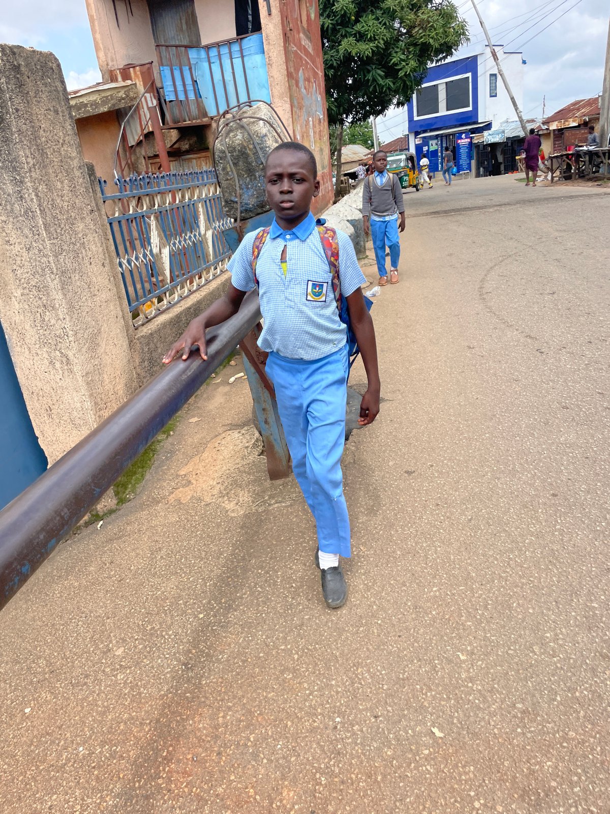Street scene with multiple people on a paved road in Jos