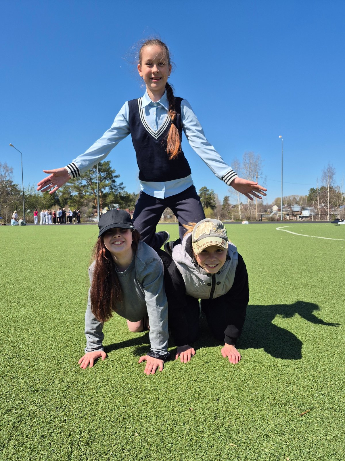Schoolgirls play and pose on sports field in Chaikovsky