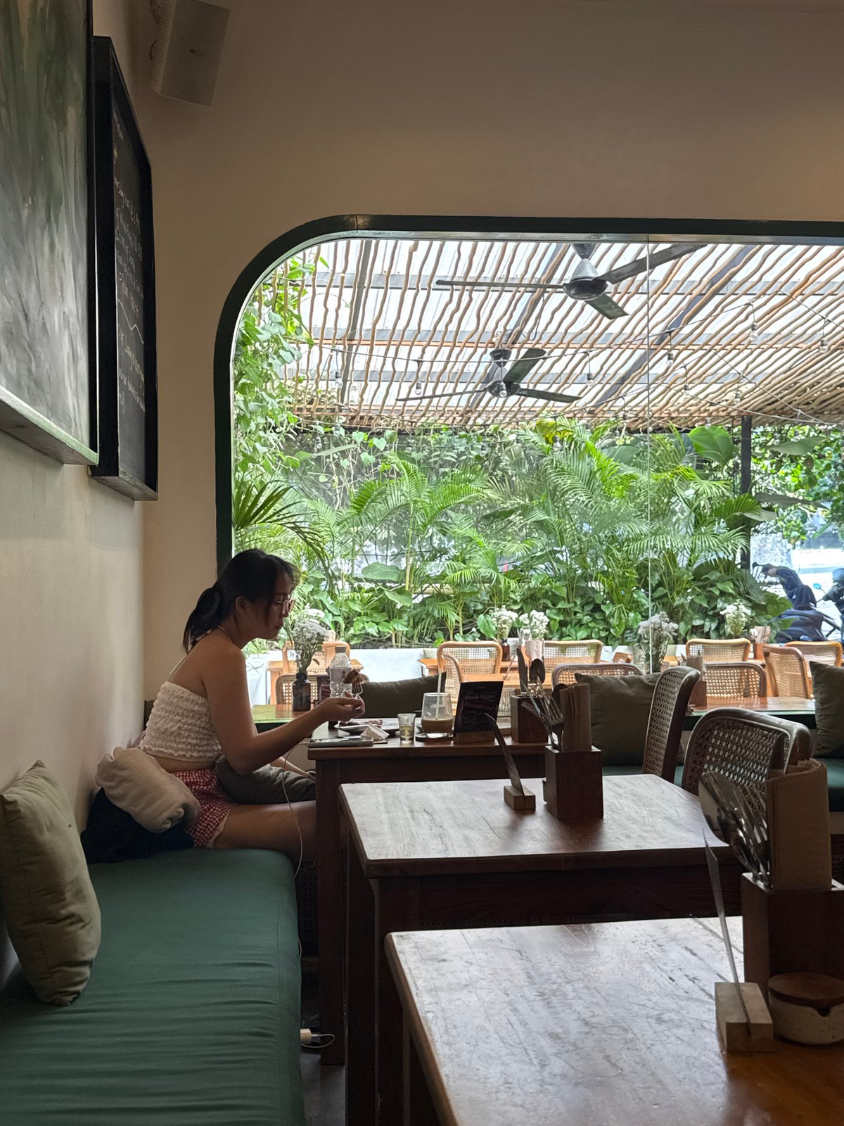 Woman enjoys morning routine in Kuta Selatan café setting