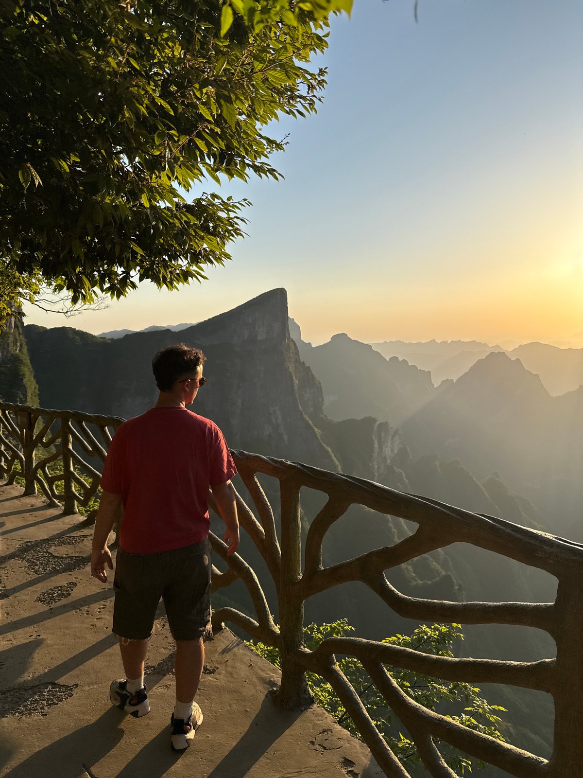 Tourist observes mountain view from deck in Yongding District