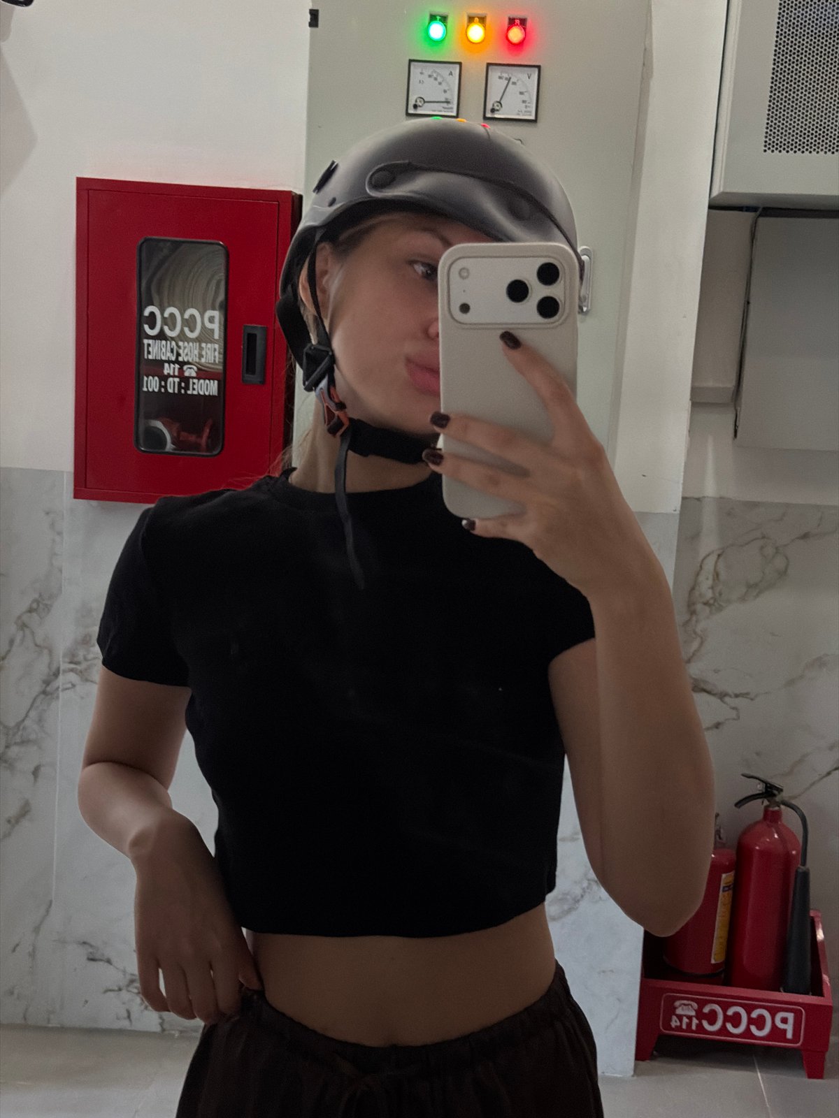 Mirror selfie in a Đà Nẵng entryway with scooters nearby