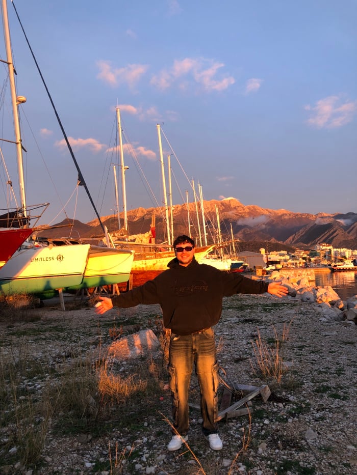 Person celebrates sunset moment at Bar Montenegro marina