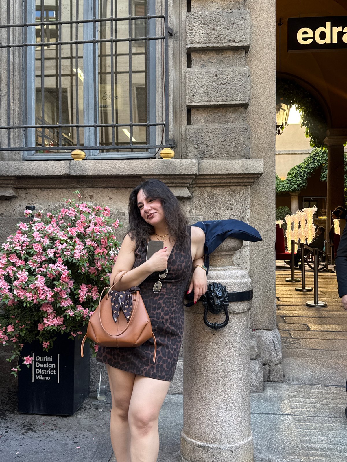 Woman poses near ornate building entrance in Milan