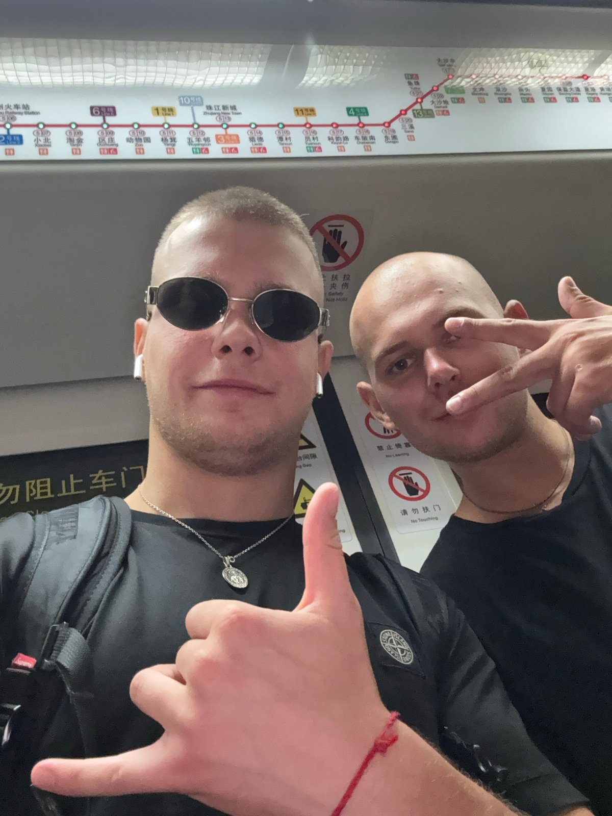 Two tourists take selfies on crowded Panyu subway train