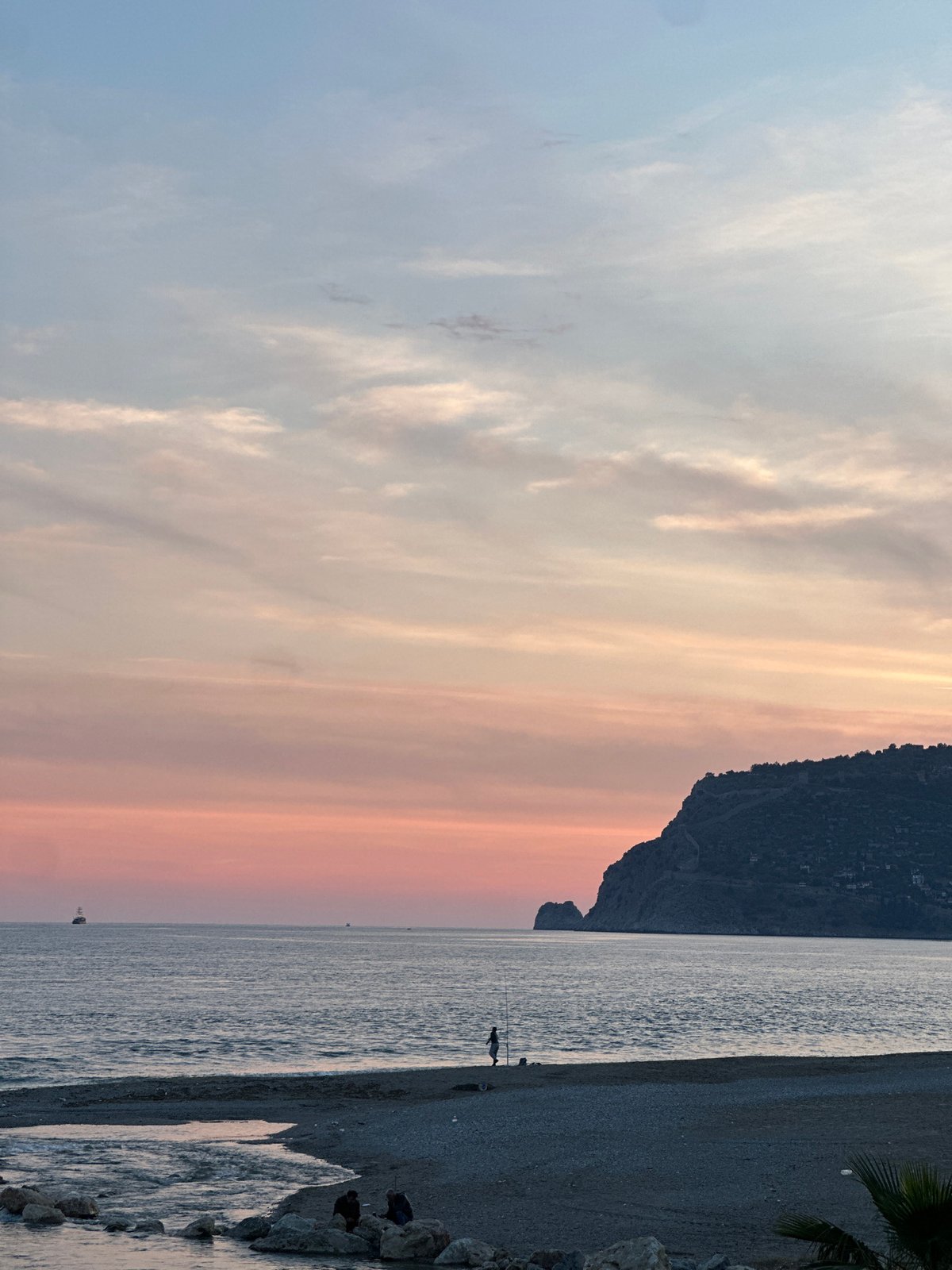 Sunset captured over Alanya beach with umbrellas and colorful sky