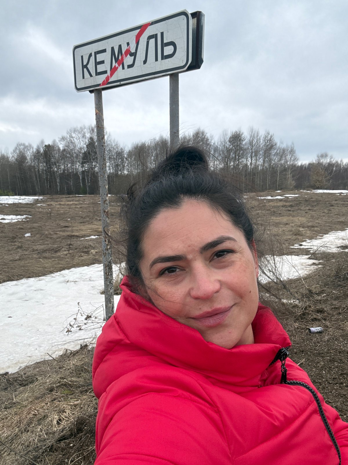 Woman photographed at Kemul city sign during early spring