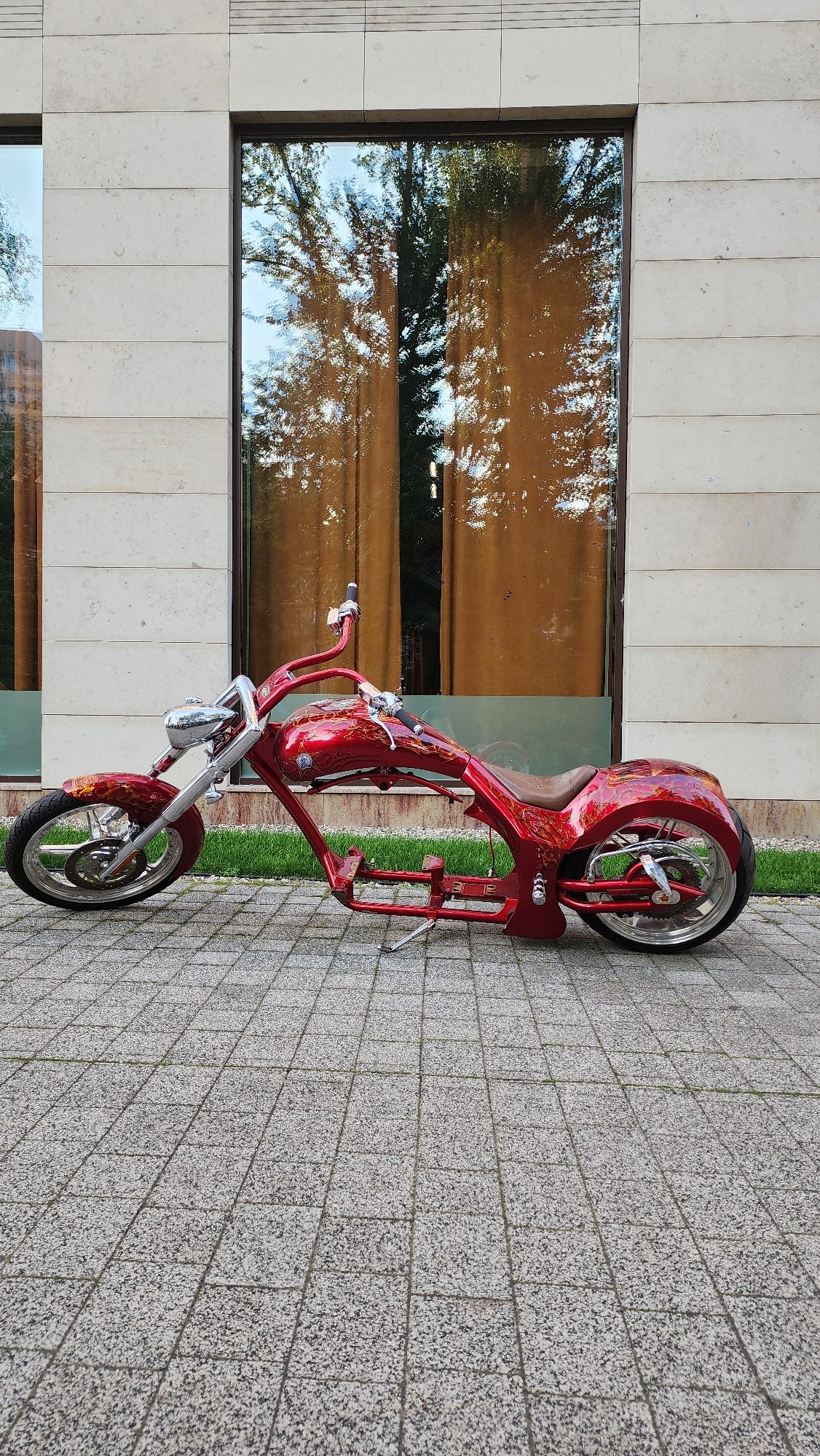Custom red chopper parked near Moscow's modern waterfront district