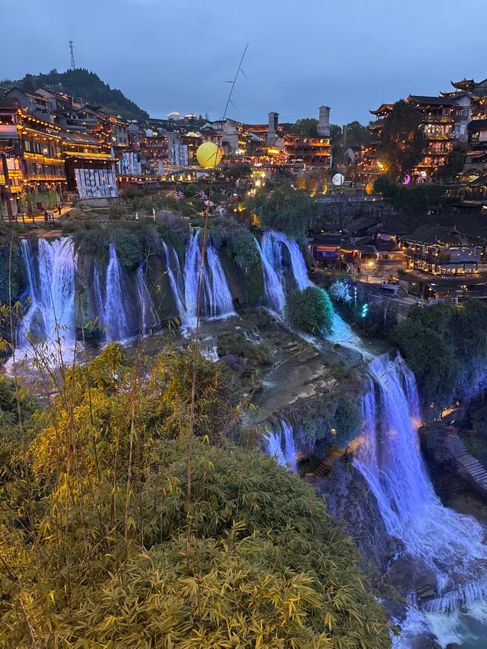Tourist documents evening visit to illuminated Furong Ancient Town