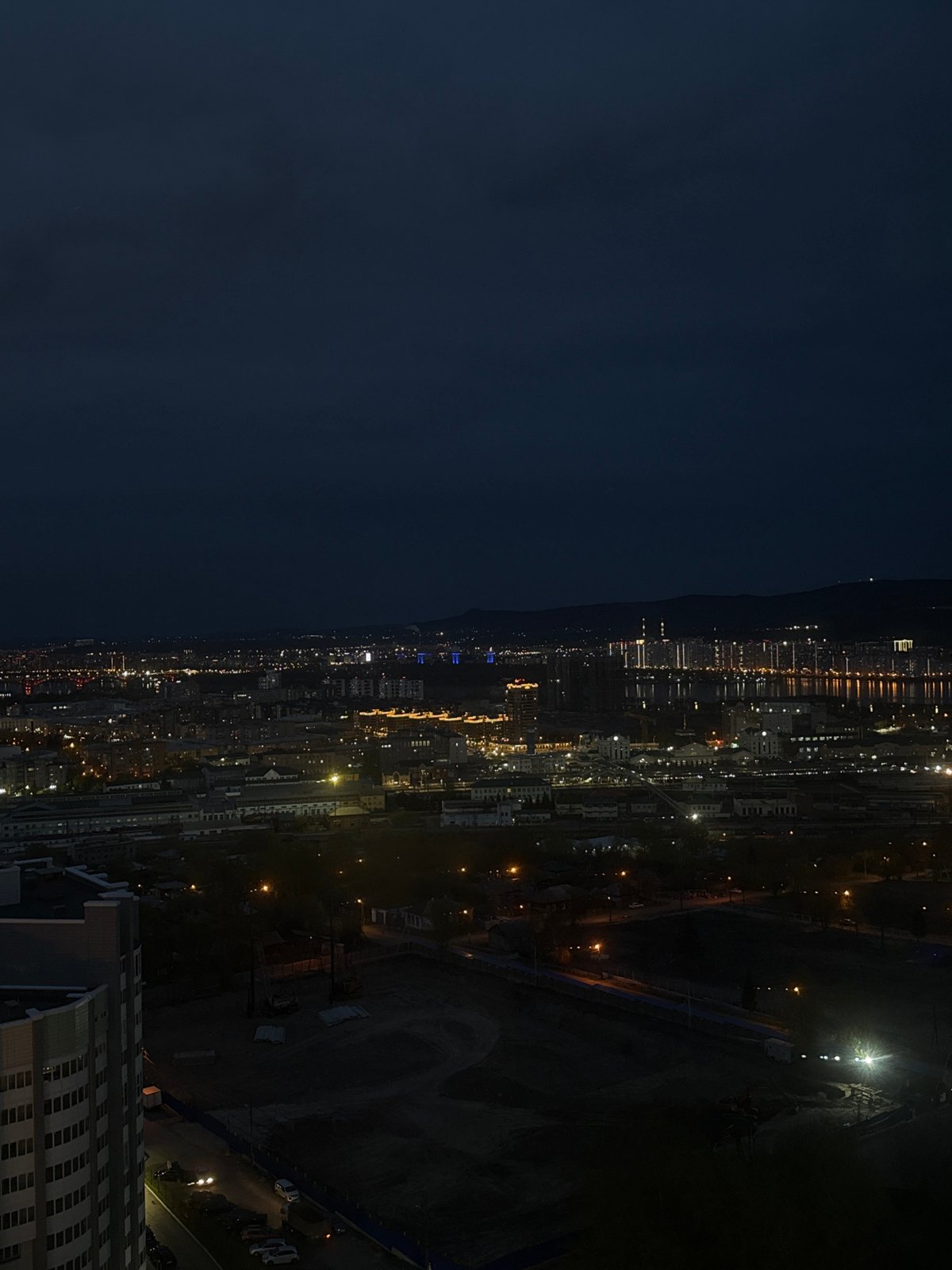 Nighttime cityscape views captured from indoor window in Krasnoyarsk