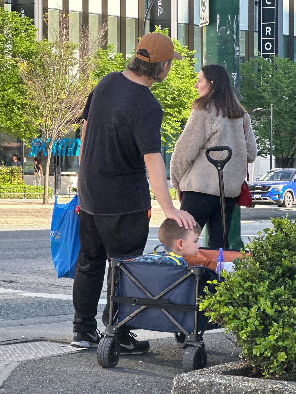 Family walks Burnaby street near modern high-rises late night